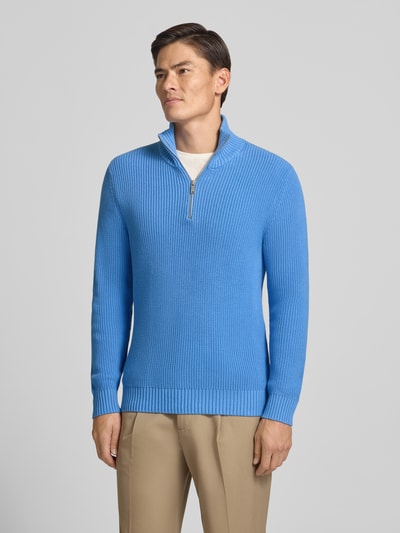 Männermodel trägt Slim Fit Strickpullover aus reiner Baumwolle mit Troyer-Kragen von MCNEAL in Blau, gerippte Abschlüsse, Ganzkörperansicht von vorne.