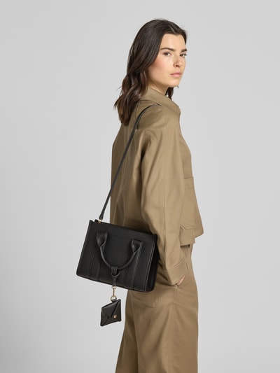 Frauenmodel trägt Handtasche in Leder-Optik Modell 'Meloy' von Seidenfelt mit Reißverschluss, abnehmbarem Schulterriemen, Hauptfach, Ganzkörperansicht Rückansicht.