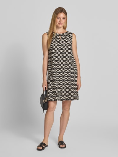 Frauenmodel trägt A-Linien Freizeitkleid aus Leinen-Viskose-Mix von Betty Barclay in Schwarz mit weißem grafischem Muster, Ganzkörperansicht von vorne.