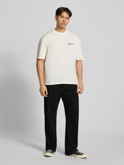 Männermodel trägt Loose Fit Sweathose mit Logo-Stitching Modell 'Signar' von Pegador, Reine Baumwolle, Schwarz, Ganzkörperansicht von vorne.