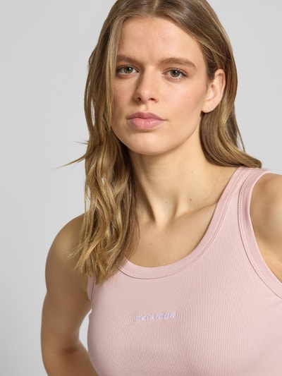 Modelka kobieca nosi różowe Tanktop mit Logo-Print Modell 'Cesis' od Pegador z bawełnianej mieszanki, faktura prążkowana, zbliżenie na górną część ciała.