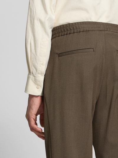 Männermodel draagt Hose aus Wolle mit Bundfalte van Filippa K in effen kleur, mat, met elastiek, bandplooi, persplooien, steekzakken, achterzakken, materiaalverwerking: geweven stof, detailaufnahme achterzijde.