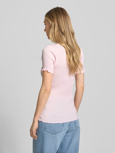 Modelka kobieca nosi damski t-shirt z prążkowaną fakturą i falistym brzegiem model 'Elaine' od MOS MOSH, jasnoróżowy, okrągły dekolt, dopasowany krój, długość tyłu w rozmiarze S/M: 61 cm, widok całej sylwetki z tyłu.