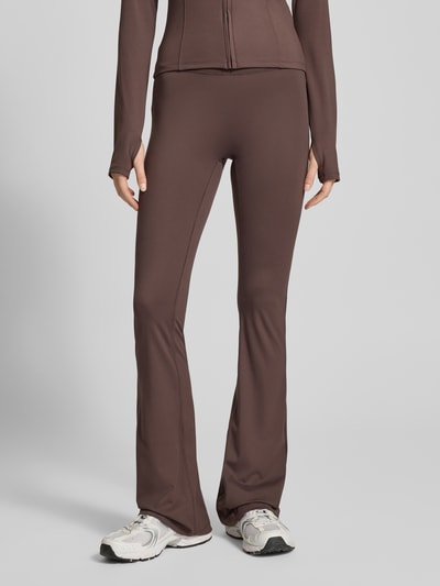 Frauenmodel trägt Flared Fit Leggings mit breitem Bund Modell 'Yoga' von Gina Tricot, elastischer Material-Mix, Nahaufnahme Unterkörper