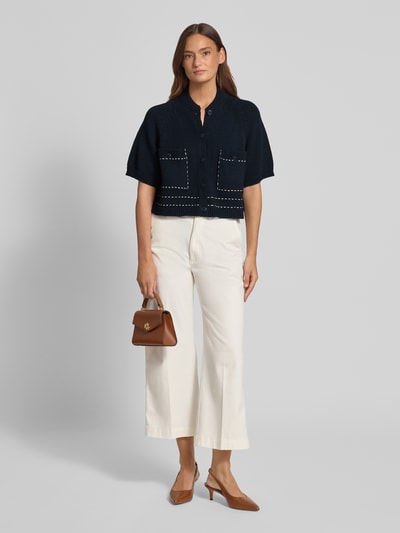 Frauenmodel trägt Regular Fit Cardigan mit Viskose-Anteil von Stefanel, dunkle Strick-Optik, Stehkragen, Halbarm, Knopfleiste, aufgesetzte Taschen, elastische Abschlüsse, Material-Mix mit Baumwoll- und Viskose-Anteil, Ganzkörperansicht von vorne.