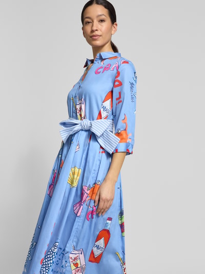 Frauenmodel trägt Hemdblusenkleid mit Bindegürtel von Milano Italy in Blau mit Allover-Look, Reine Baumwolle, Taillierter Schnitt, Midikleid, Hemdblusenkragen, Ganzkörperansicht von vorne. Rückenlänge bei Größe 36: 120 cm, Brustweite: 43 cm, Ärmellänge: 45 cm.