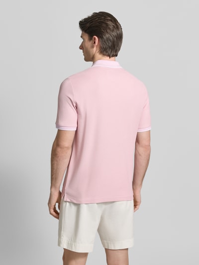 Männermodel trägt Modern Fit Poloshirt mit Stitching von Fynch-Hatton in Rosa, reine Baumwolle, weiße Shorts, Ganzkörperansicht Rückansicht.