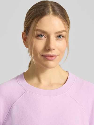 Frauenmodel trägt Sweatshirt mit stark überschnittenen Schultern Modell 'ATUBAY' von American Vintage in Flieder, Baumwoll-Mix, Nahaufnahme Oberkörper.