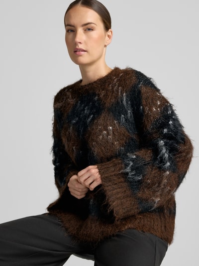 Vrouwenmodel draagt Relaxed Fit gebreide pullover uit wolmix van Neo Noir, bruine en zwarte kleuren, ronde hals, lange mouw, ruglengte maat 36: 61 cm, mouwlengte maat 36: 45 cm, damessweater, vooraanzicht bovenlichaam.