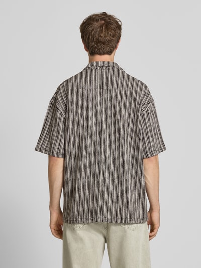 Männermodel trägt Relaxed-Fit Freizeithemd mit Label-Stitching Modell 'Forno' von Pegador, Allover-Look, Reine Baumwolle, Ganzkörperansicht Rückansicht.