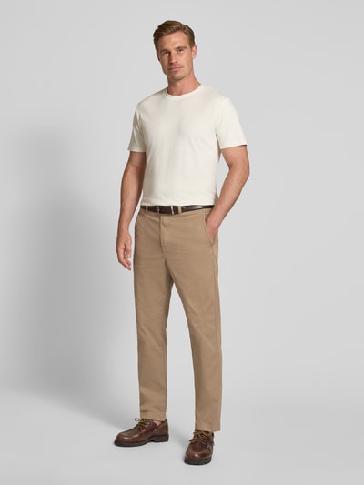 Männermodel trägt Relaxed Fit Chino aus Baumwoll-Mix von Tom Tailor Denim in Beige und weißes Shirt, Ganzkörperansicht von vorne, Herren Chino von Tom Tailor Denim