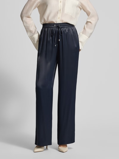 Frauenmodel trägt Wide Leg Hose aus reiner Viskose Modell 'TAVATI' von BOSS in Dunkelblau, satinierte Textur, unifarben, Ganzkörperansicht von vorne.