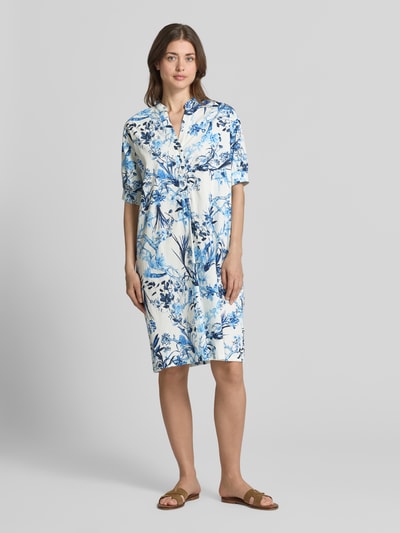 Frauenmodel trägt Knielanges Hemdblusenkleid mit Tunika-Ausschnitt von ROBE LÉGÈRE im floralen-Allover-Print, aus Baumwoll-Mix, Relaxed-Fit, Knielänge, kurzärmelig, Knopfleiste, Weiß und Blau, Ganzkörperansicht von vorne.