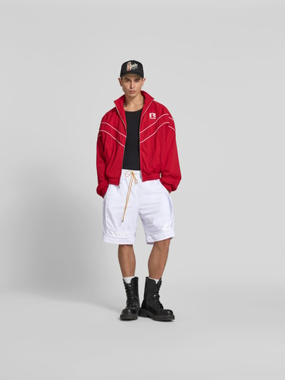 Männermodel trägt Shorts mit elastischem Bund von RHUDE, lockerem Schnitt, Tunnelzug, Mesh, Eingrifftaschen, Weiß, Ganzkörperansicht von vorne.