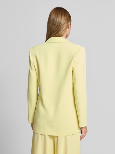 Frauenmodel trägt Blazer mit Reverskragen Modell 'REWI' von Rinascimento in Hellgelb, gerader Schnitt, glatte Oberfläche, Ganzkörperansicht Rückansicht.