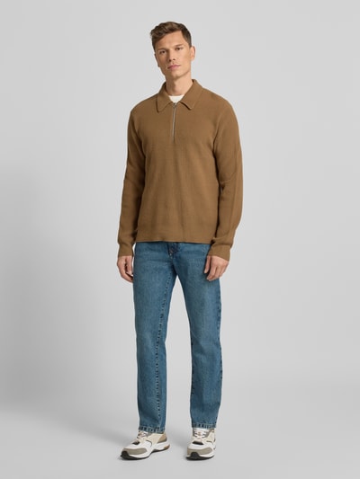 Männermodel trägt Loose Fit Jeans im 5-Pocket-Design von MCNEAL, reine Baumwolle, mittelblaue Farbe, Ganzkörperansicht von vorne.