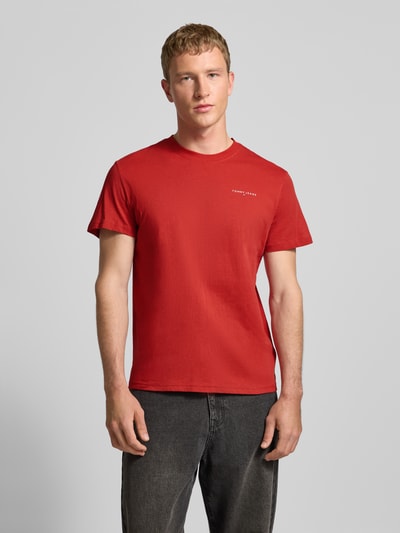 Männermodel trägt Slim Fit T-Shirt aus reiner Baumwolle von Tommy Jeans, Optik: Unifarben, Passform: Slim-Fit, Label-Print, Rundhals, Kurzarm, Material: Reine Baumwolle, Ganzkörperansicht von vorne.