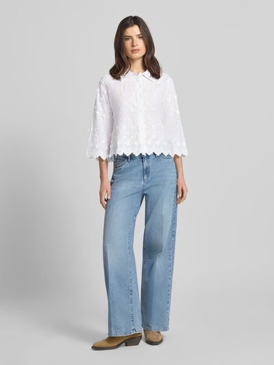 Modelka nosi Slim Fit Hemdbluse mit 3/4-Arm von Apricot z bawełny z wykładanym kołnierzem, listwą guzikową, rękaw o dł. 3/4, długość tyłu w rozmiarze S: 56 cm, długość rękawów w rozmiarze S: 48 cm, biała, tekstura haftu, widok całej sylwetki z przodu.