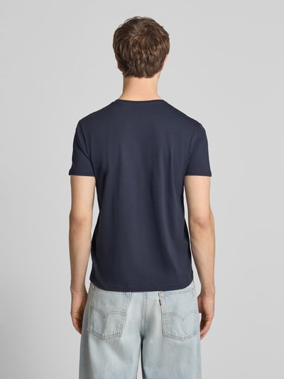 Männermodel trägt T-Shirt mit Label-Detail Modell 'BASIC' von Alpha Industries in Dunkelblau, Reine Baumwolle, Gerader-Schnitt, Rückenlänge 69 cm, Ganzkörperansicht Rückansicht.