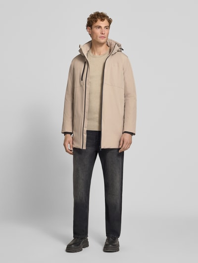 Męski model prezentuje Regular Fit Parka mit Logo-Print od Lindbergh, beż, elastyczna mieszanka materiałów, kaptur z tunelem, długi rękaw, zamek błyskawiczny, Szerokość ramion w rozmiarze M: 50 cm, Szerokość klatki piersiowej w rozmiarze M: 58 cm, Długość tyłu w rozmiarze M: 90 cm, Długość rękawów: 65 cm, widok całej sylwetki z przodu.