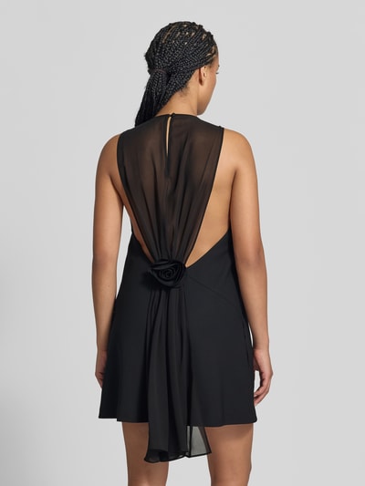 Frauenmodel trägt Relaxed Fit Kleid in Knielänge von ROTATE, schwarz, ärmellos, elastischer Material-Mix, Rückansicht, Detailaufnahme.