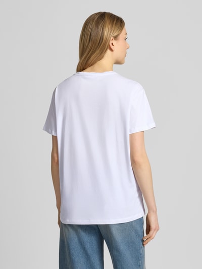 Frauenmodel trägt T-Shirt mit Motiv und Ziersteinbesatz von Liu Jo White in Weiß, reine Baumwolle, Relaxed Fit, Ganzkörperansicht Rückansicht.