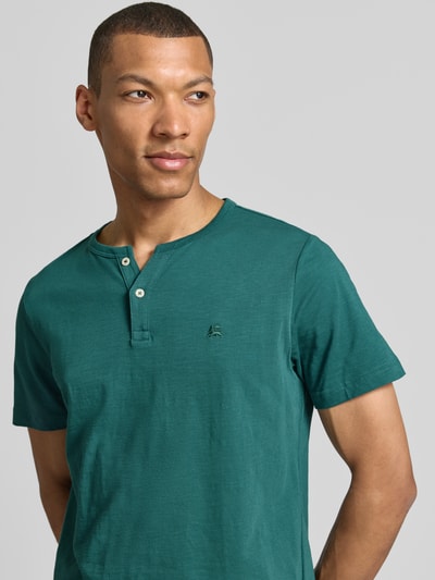 Männermodel trägt T-Shirt mit kurzer Knopfleiste von Lerros in Grün, Reine Baumwolle, Gerader-Schnitt, Logo-Stitching, Nahaufnahme Oberkörper.