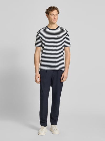 Männermodel trägt Regular Fit T-Shirt aus reiner Baumwolle von Marc O'Polo, gestreift, Allover-Muster, Jersey, Ganzkörperansicht von vorne.