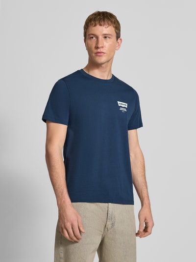 Männermodel trägt T-Shirt mit Label-Detail und Logo-Print von Levi's®, reine Baumwolle, körpernaher Schnitt, Gerippter Rundhalsausschnitt, Logo- und Motiv-Print, Label-Detail, Rückenlänge bei Größe M 68 cm, einfarbig blau, glatte Struktur, Ganzkörperansicht von vorne.