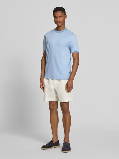Männermodel trägt Slim Fit T-Shirt aus reine katoen Modell 'H-TESSLER 238' van BOSS, effen lichtblauw, contrasterende naden, ronde hals, korte mouw, ganzkörperansicht von vorne.