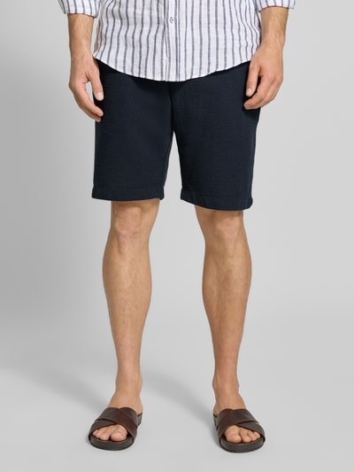 Männermodel trägt Shorts mit elastischem Bund und Tunnelzug von MCNEAL aus Baumwoll-Mix, Regular-Fit, dunkelblau, Nahaufnahme Unterkörper.