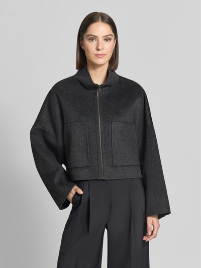 Frauenmodel trägt Jacke aus Woll-Mix mit Reißverschluss Modell 'ELSTOW' von DRYKORN in Dunkelgrau, Boxy Fit, Ganzkörperansicht von vorne.