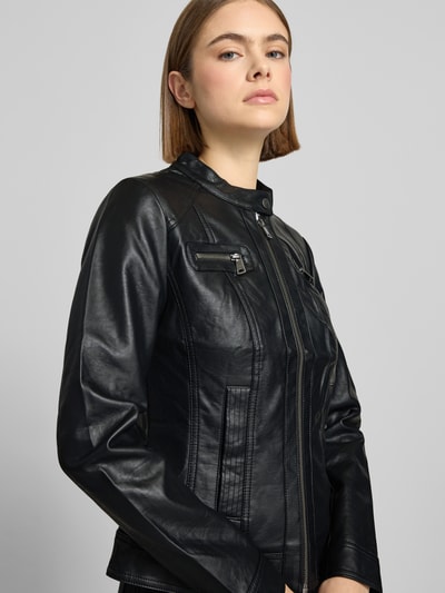 Frauenmodel trägt Jacke im authentischen Leder-Look von Only, schwarze Farbe, Stehkragen mit Riegel, Reißverschluss, taillierter Schnitt, zwei Brusttaschen mit Reißverschluss, zwei Eingrifftaschen, Rückenlänge 56 cm, Schulterbreite 37 cm, Ärmellänge 62 cm; Ganzkörperansicht von vorne.