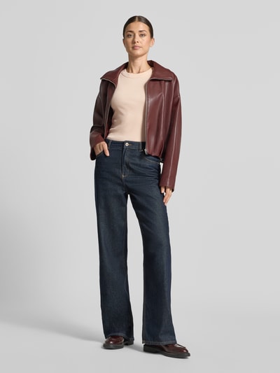 Kobiece modelka nosi Skinny Fit Tanktop aus reiner Baumwolle od DRYKORN w kolorze beżowym, efekt prążkowania, okrągły dekolt, długość tyłu w rozmiarze S to 54 cm, widok na całe ciało z przodu.