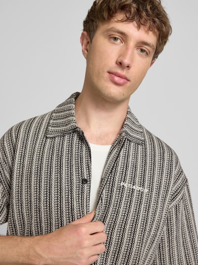 Männermodel trägt Relaxed-Fit Freizeithemd mit Label-Stitching Modell 'Forno' von Pegador, Reine Baumwolle, Allover-Look, Nahaufnahme Oberkörper.