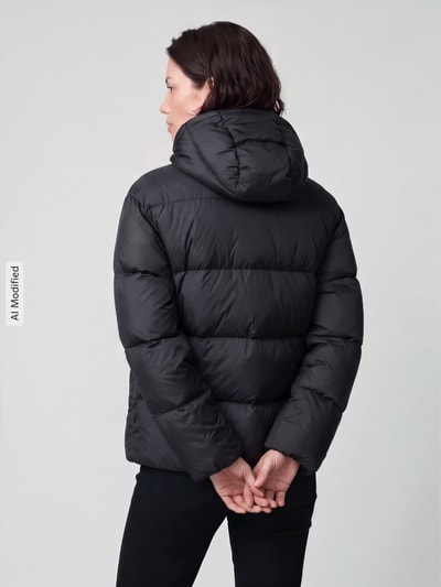 Frauenmodel trägt schwarze Daunenjacke mit abnehmbarer Kapuze von Polo Ralph Lauren, glatte Textur, Ganzkörperansicht Rückansicht, KI-modifiziertes Bild.