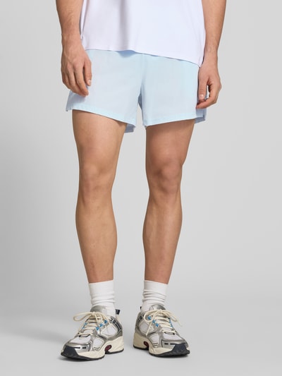 Männermodel trägt Shorts mit elastischem Bund Modell 'ERUDITO' von Ellesse, hellblau, Material-Mix mit Stretch-Anteil, Regular-Fit, Nahaufnahme Oberschenkel.
