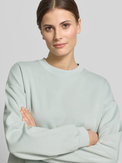 Frauenmodel trägt Sweatshirt mit Knopfleiste Modell 'Tessina' von JOOP!, mintgrün, glatter Material-Mix, Regular Fit, Nahaufnahme Oberkörper.