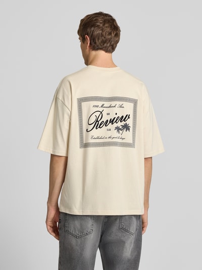 Männermodel trägt T-Shirt mit Rundhalsausschnitt und Label-Print von REVIEW in Beige, Relaxed-Fit, Reine Baumwolle, Rückenlänge 71 cm, Ganzkörperansicht Rückansicht.