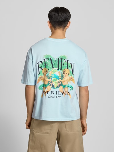 Männermodel trägt T-Shirt mit überschnittenen Schultern von REVIEW, Reine Baumwolle, Lockerer-Schnitt, Label-Print, Rückenlänge 70 cm, Ganzkörperansicht Rückansicht.