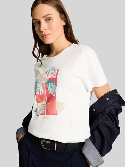 Modelka nosi Regular Fit T-Shirt aus reiner Baumwolle von Tom Tailor, biała koszulka z motywem nadruku i label print, jersey, przód, zbliżenie na górną część ciała