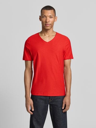 Męski model nosi Regular Fit T-Shirt mit V-Ausschnitt od MCNEAL z bawełny, krój regular fit, dekolt w serek, zrolowany brzeg, długość tyłu w rozmiarze M: 70 cm, widok całej sylwetki z przodu.