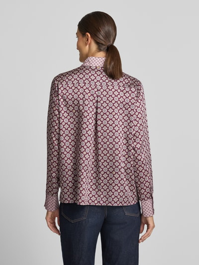 Frauenmodel trägt Relaxed Fit Hemdbluse Modell 'CAMICIA' von Liu Jo White in Satin mit geometrischem Muster, Rückenansicht, Kontext: Damen Hemdbluse von Liu Jo White, Satin, Relaxed Fit, Modell 'CAMICIA', Hemdblusenkragen, langärmeliges Design, Brusttasche, Rückenlänge bei Größe 36: 64 cm, Ärmellänge bei Größe 36: 62 cm.