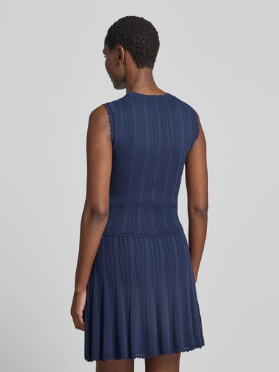 Frauenmodel trägt Stricktop in Pointelle-Strick mit kurzer Knopfleiste von GUESS, Viskose-Mix, Modell 'CARMEN', Rückansicht, Ganzkörperansicht.