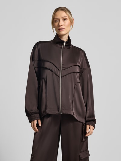 Frauenmodel trägt Relaxed Fit Jacke mit Stehkragen Modell 'Darzi' von Gestuz, glattes dunkelbraunes Material, Ganzkörperansicht von vorne. Elastischer Material-Mix, markante Nähte und seitliche Taschen, Damen Jacke.