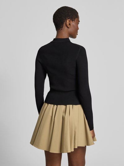 Frauenmodel trägt Slim Fit Jacke aus Viskose-Mix von Victoria Beckham in Schwarz mit Polokragen, Strick-Optik, Reißverschluss, Rückenlänge 49 cm, Ganzkörperansicht Rückansicht.