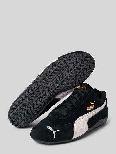 Produktfoto, Sneaker aus echtem Leder Modell 'Speedcat' von PUMA in Schwarz mit weißem Logo-Detail, runder Passform, glatter Sohle, seitlicher Ansicht, Kontext: Damen Sneaker, Schnürverschluss, Absatzhöhe 2 cm, Schafthöhe 7 cm, Schaftweite 8 cm.