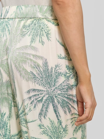 Frauenmodel trägt Regular Fit Weite Hose aus reiner Viskose von s.Oliver BLACK LABEL mit Palmenprint in Grün und Beige, Nahaufnahme Hüfte.