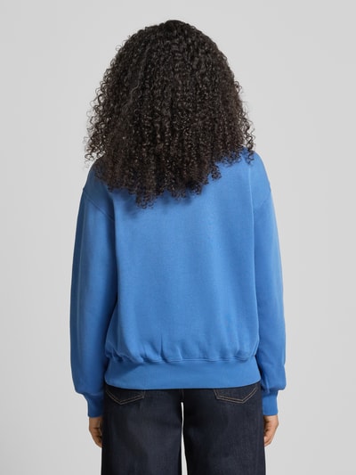 Kobiece model prezentuje bluzę Sweatshirt mit Label-Stitching od Polo Ralph Lauren, mieszanka bawełny, luźny krój, prążkowane wykończenia, okrągły dekolt, wyhaftowane logo, widok całej sylwetki z tyłu.