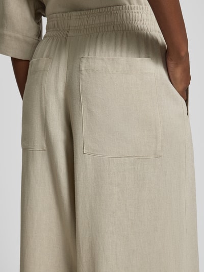 Frauenmodel trägt Hose aus Leinen-Viskose-Mix Modell 'CEILING' von Drykorn, beigefarbener Stoff, breite Form, elastischer Bund, Detailaufnahme Rückansicht. Damen Hose Wide Leg, Bundweite 38 cm, Innenbeinlänge 80 cm.